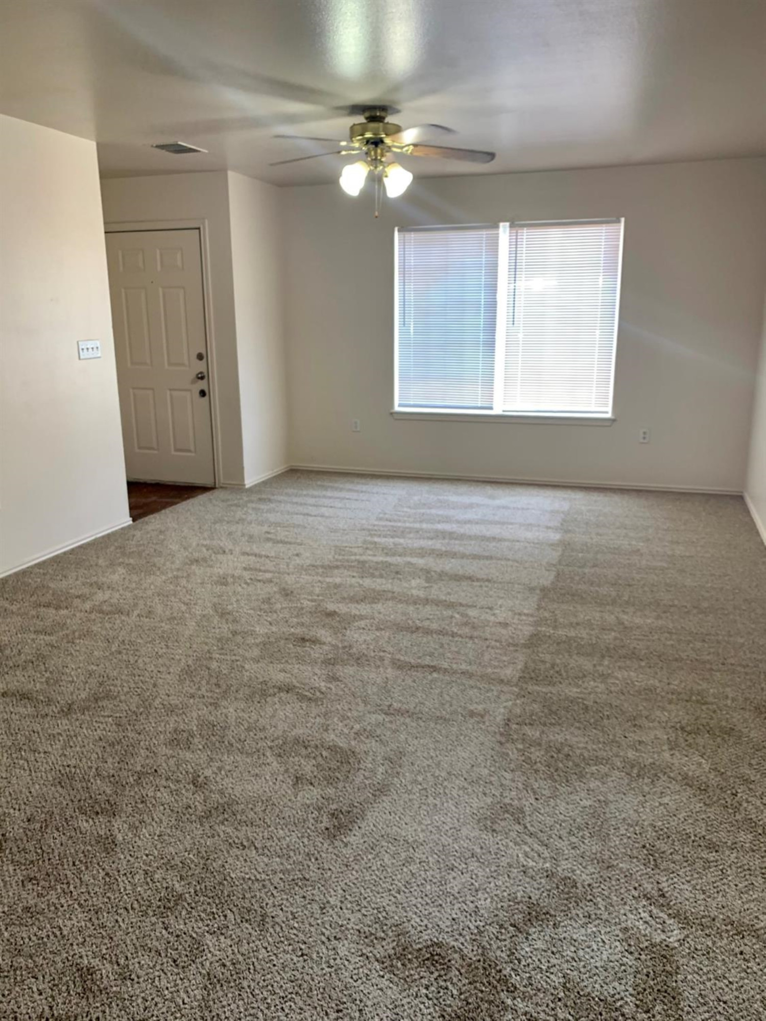 1108 82nd Street, Unit A Lubbock, TX 79423 - Photo 2 of 8 an empty room with windows and fan