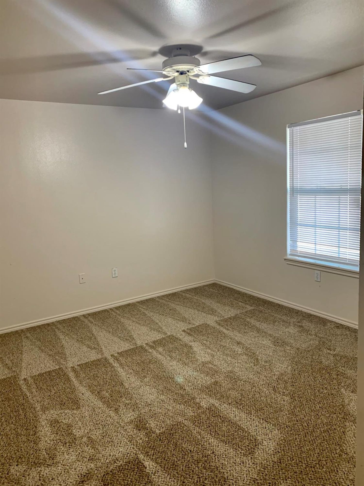 1108 82nd Street, Unit A Lubbock, TX 79423 - Photo 5 of 8 a view of a room with a ceiling fan and a window