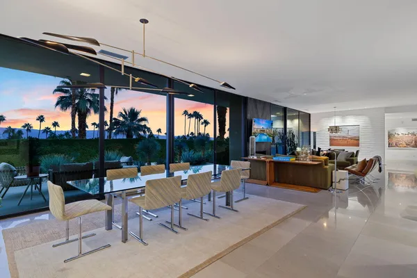 a dining room with furniture and a floor to ceiling window