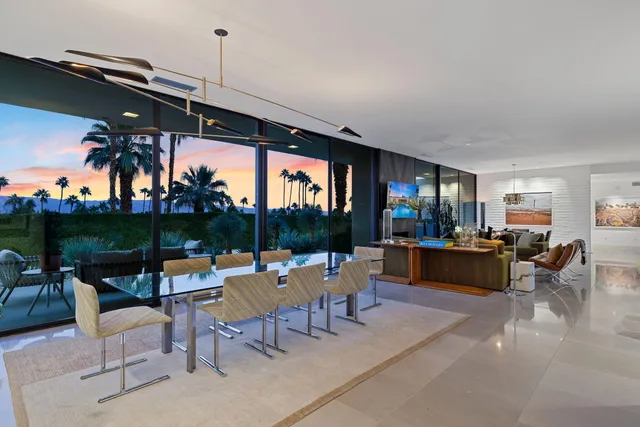 a dining room with furniture and a floor to ceiling window