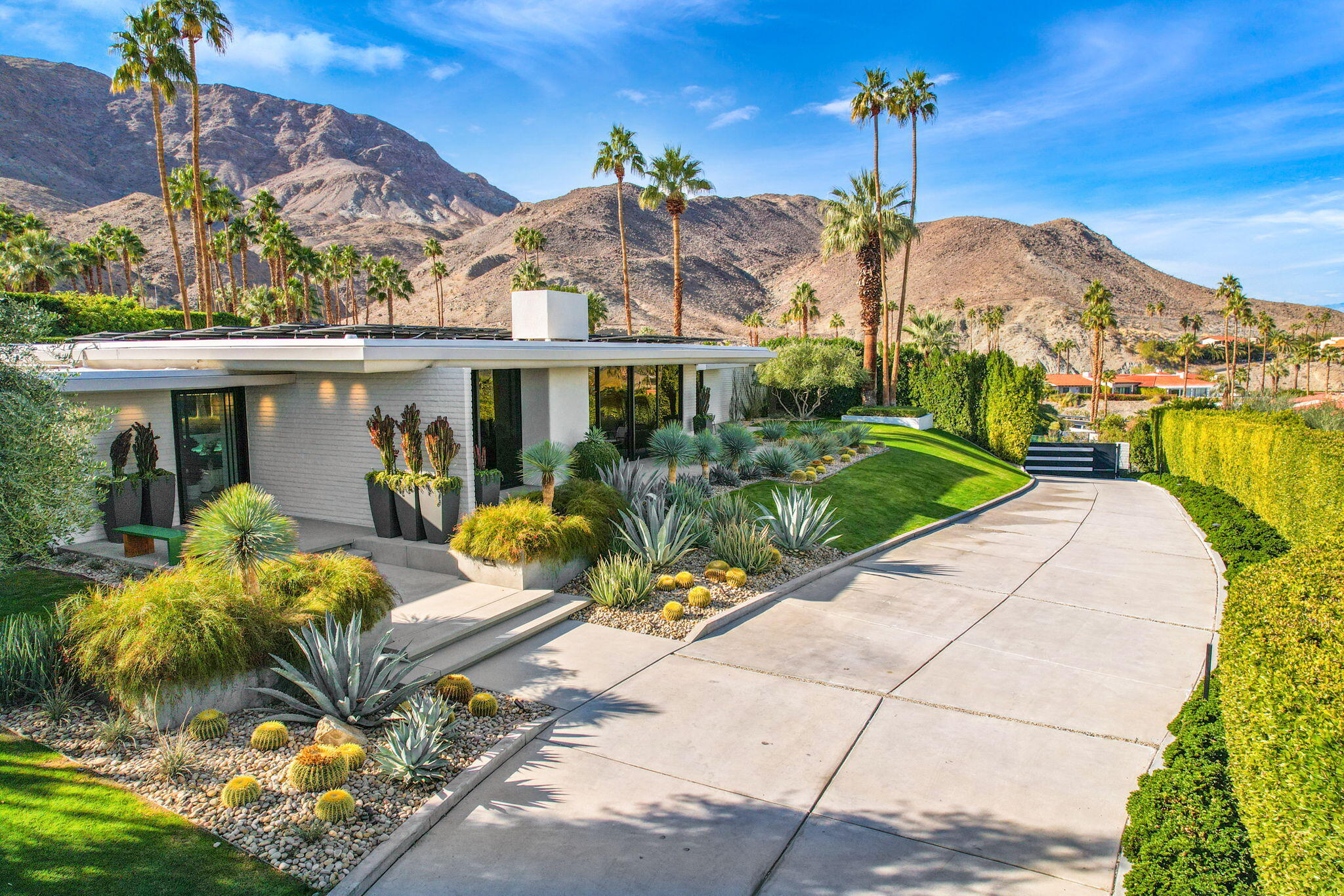 70149 Sonora Road Rancho Mirage, CA 92270 - Photo 21 of 74 a front view of a house with a yard and potted plants