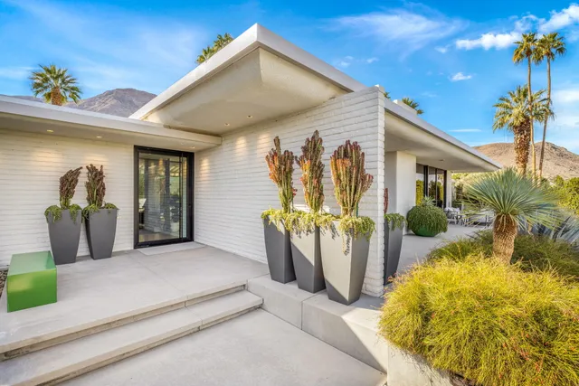 a living room with patio furniture and a potted plants