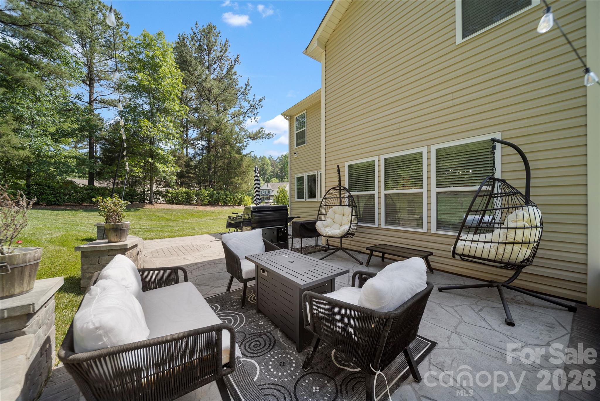 8122 Mossy Rock Road Waxhaw, NC 28173 - Photo 26 of 28 a view of a patio with couches chairs and a fire pit