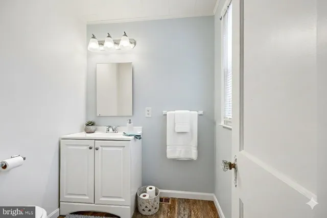 a bathroom with a light fixture a sink and a mirror