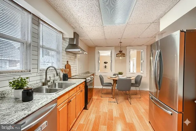 a dining room with stainless steel appliances kitchen island granite countertop furniture and a potted plant