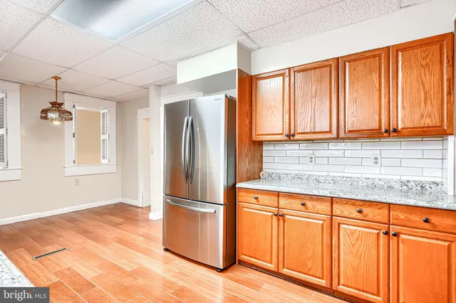 a kitchen with granite countertop a refrigerator and cabinets