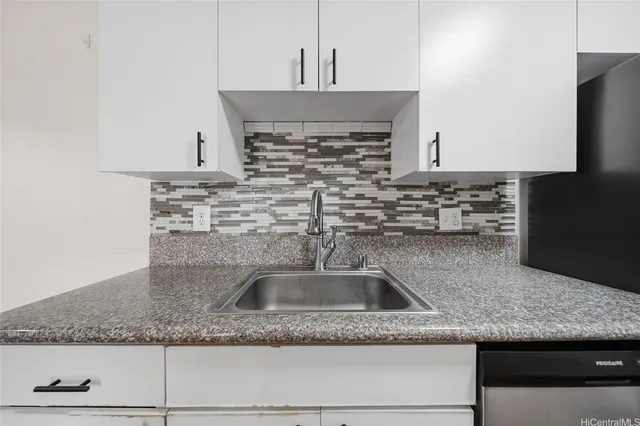 a kitchen with granite countertop a sink and a stove