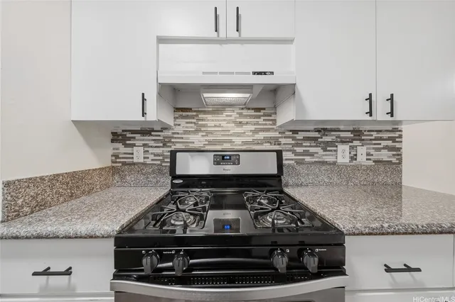a stove top oven sitting inside of a kitchen