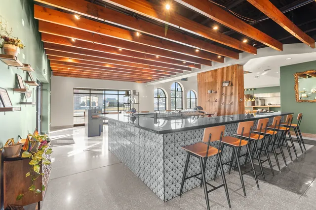 a dining hall with couches a dining table and chairs with wooden floor