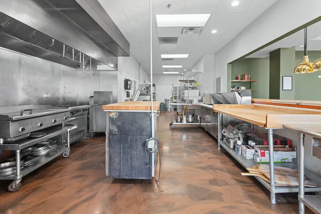 a kitchen with stainless steel appliances kitchen island granite countertop a sink and cabinets