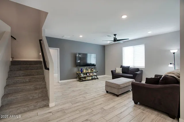 a kitchen with stainless steel appliances kitchen island granite countertop a dining table chairs and refrigerator