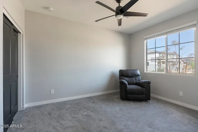 an empty room with a window and a fan