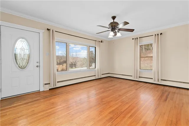 a view of empty room with wooden floor and fan