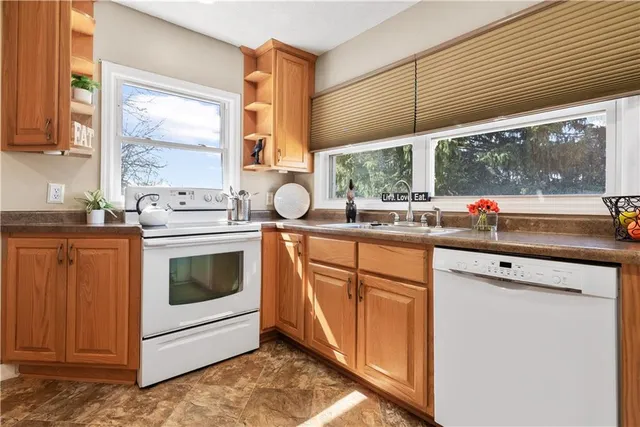 a kitchen with stainless steel appliances sink cabinets and window