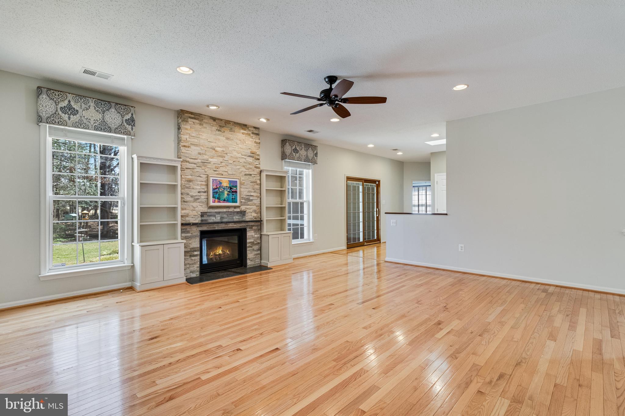 14850 King Charles Drive Issue, MD 20645 - Photo 11 of 63 a view of a livingroom with a fireplace a ceiling fan and window