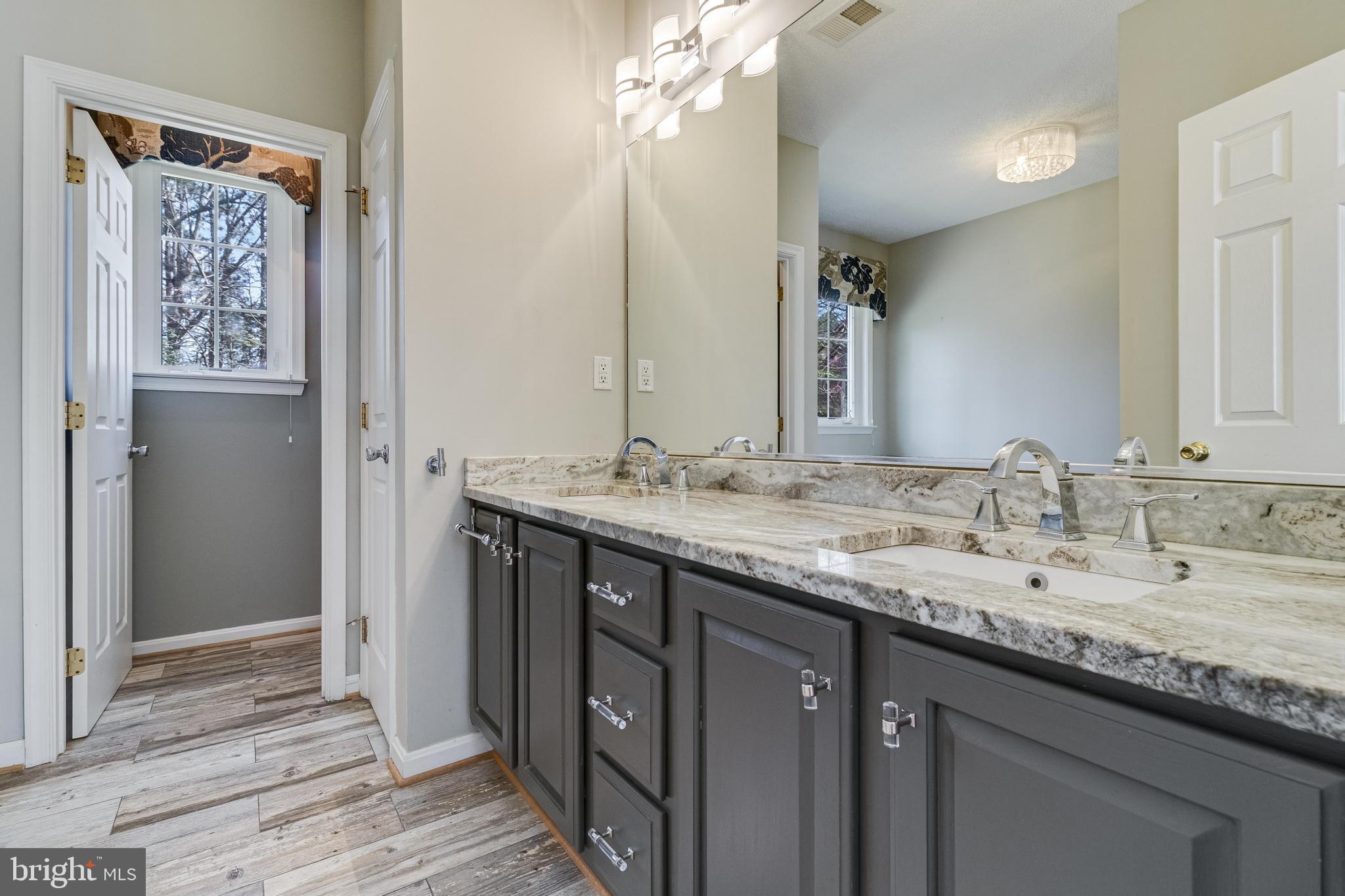 14850 King Charles Drive Issue, MD 20645 - Photo 31 of 63 a bathroom with a granite countertop sink a large mirror and a shower