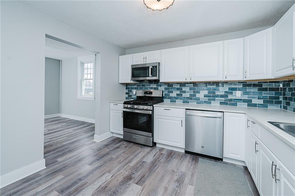 887 Millville Road Altoona, PA 16601 - Photo 12 of 29 a kitchen with granite countertop a stove top oven a sink dishwasher and a refrigerator with wooden floor