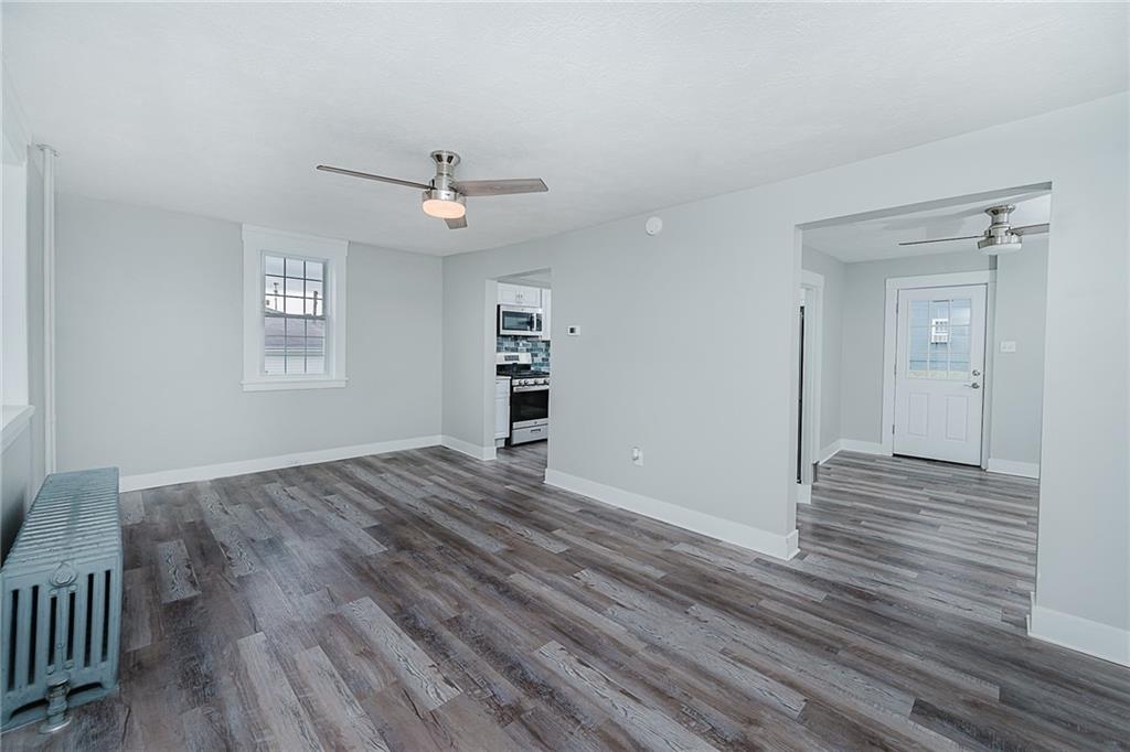 887 Millville Road Altoona, PA 16601 - Photo 5 of 29 an empty room with wooden floor chandelier fan and windows