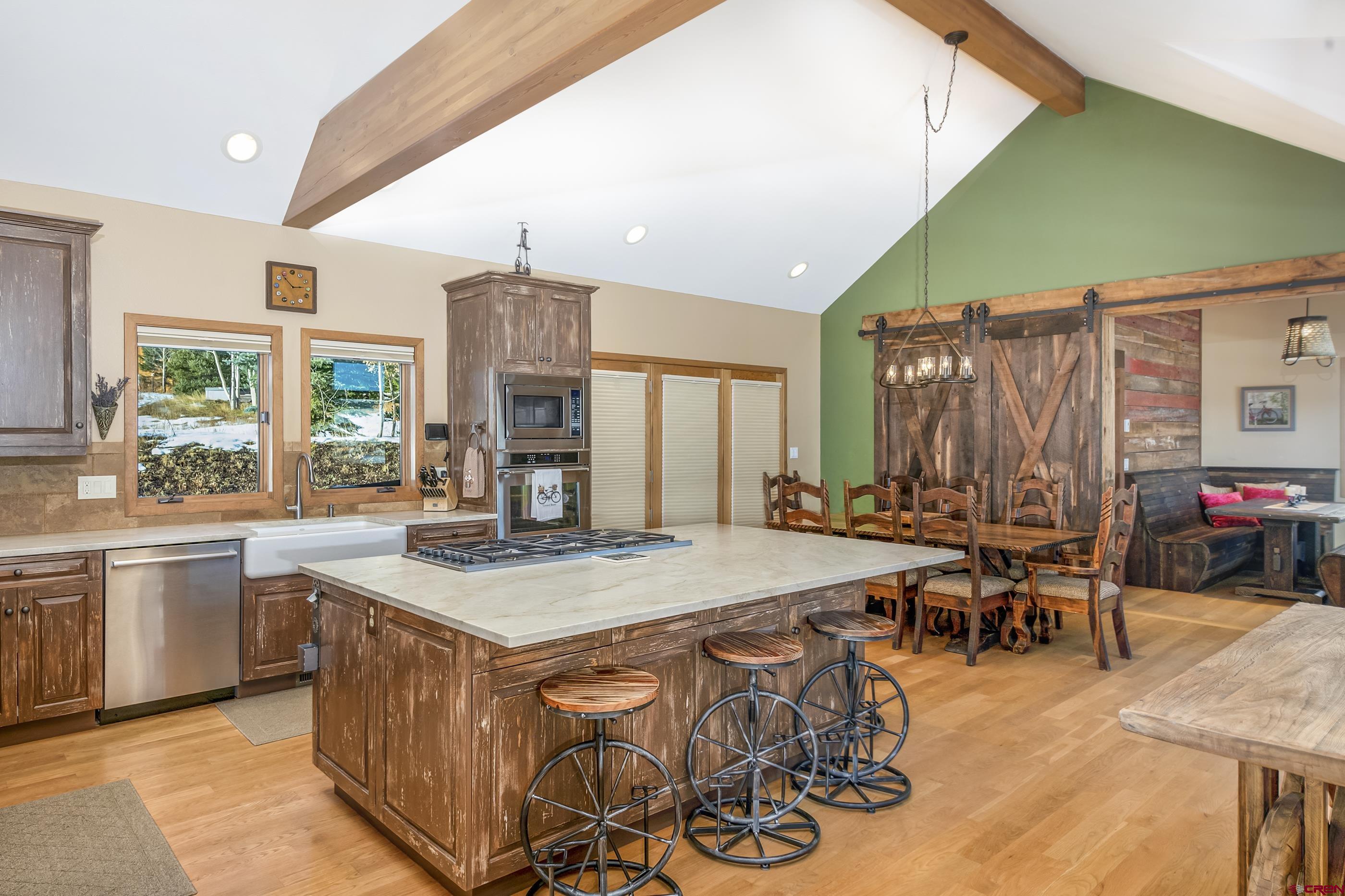 15 Nicholson Lane Crested Butte, CO 81224 - Photo 12 of 42 a kitchen with stainless steel appliances kitchen island granite countertop a table chairs and a refrigerator