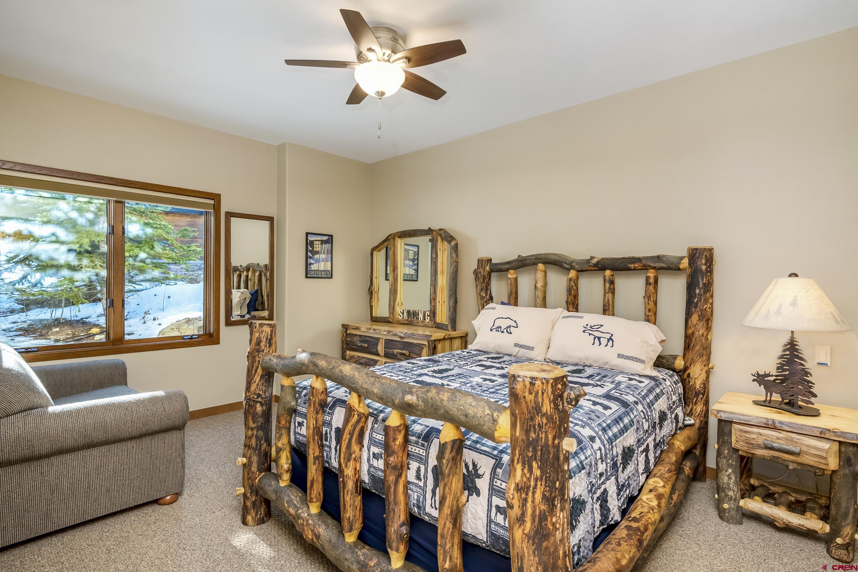 15 Nicholson Lane Crested Butte, CO 81224 - Photo 24 of 42 a bedroom with a bed a couch and a chandelier