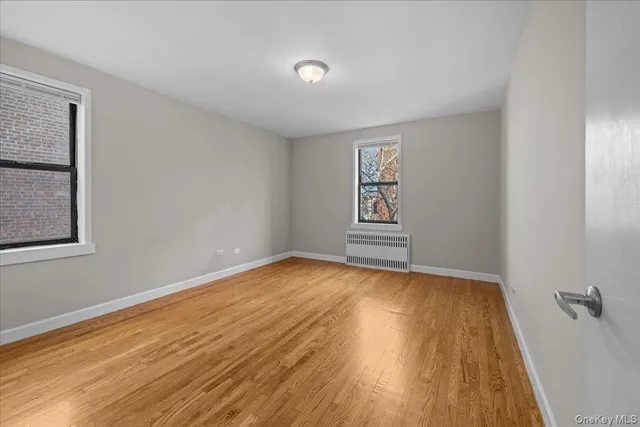 a view of an empty room with wooden floor