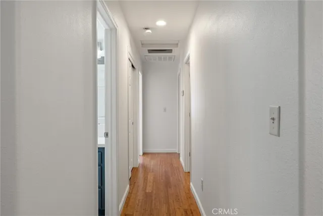 a view of a hallway with wooden floor