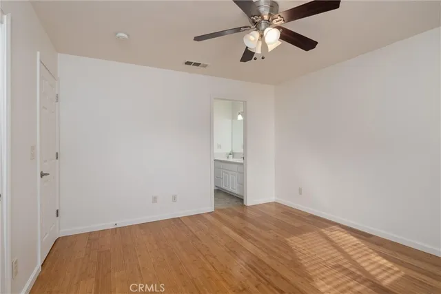an empty room with a ceiling fan and a window