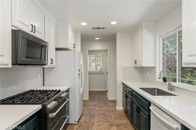 a kitchen with stainless steel appliances granite countertop a sink stove and microwave