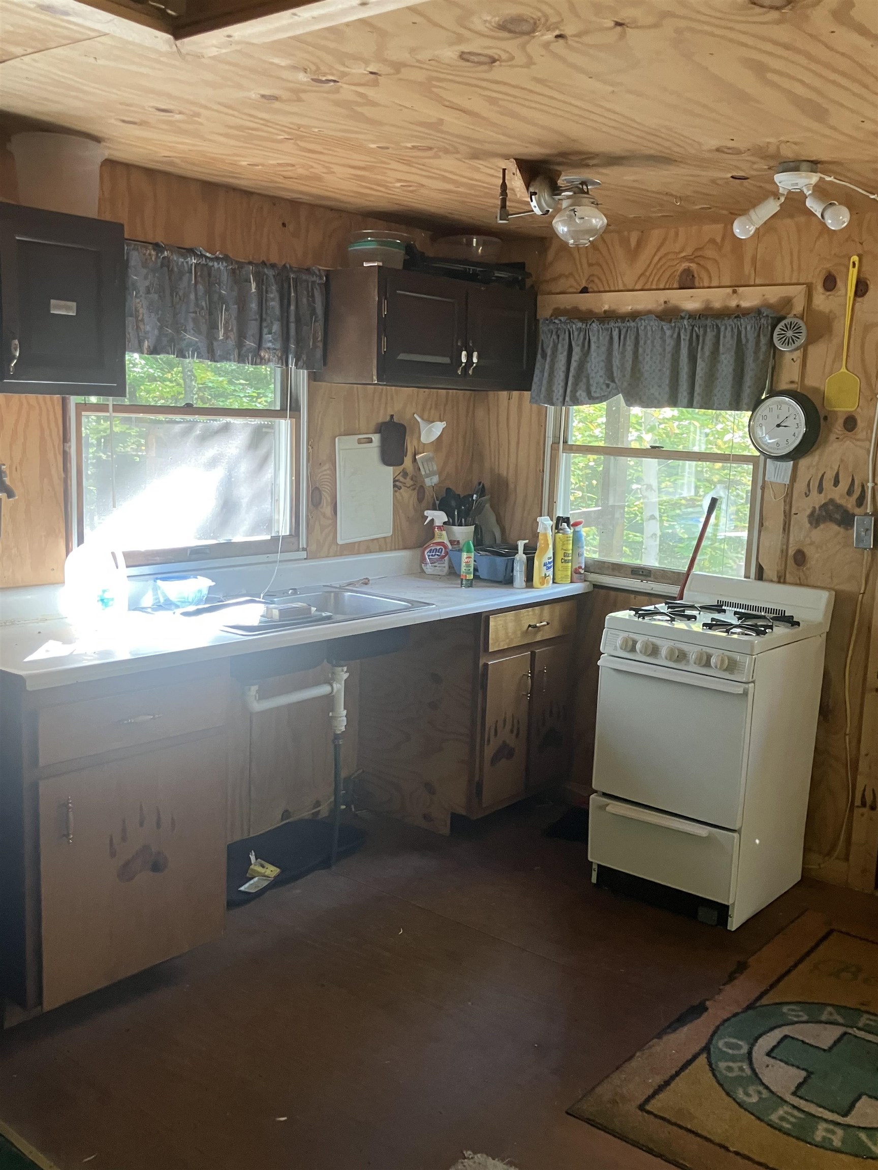 44890 Potato River Road Saxon, WI 54559 - Photo 6 of 16 Kitchen featuring gas range gas stove, light countertops, plenty of natural light, wooden walls, and electric panel