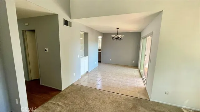 a view of a hallway with wooden floor and a bathroom