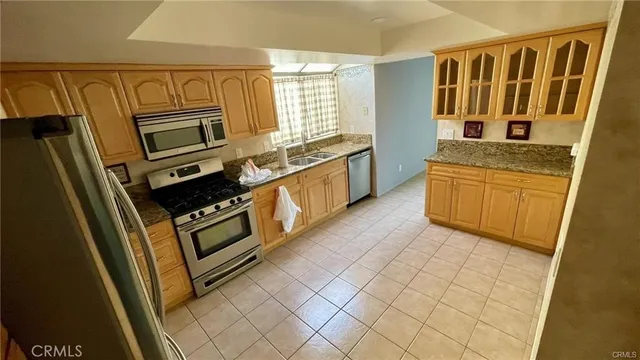 a kitchen with stainless steel appliances granite countertop a stove a sink and a refrigerator