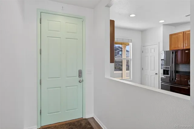 a view of a kitchen counter top space a sink a refrigerator and a window