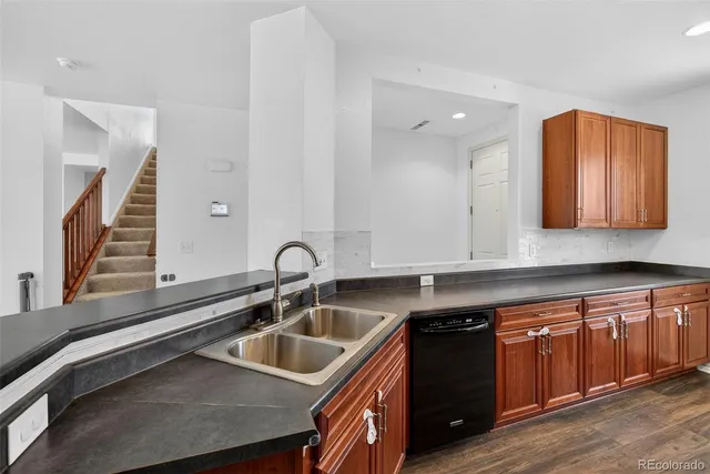 a kitchen with stainless steel appliances granite countertop a refrigerator stove and sink
