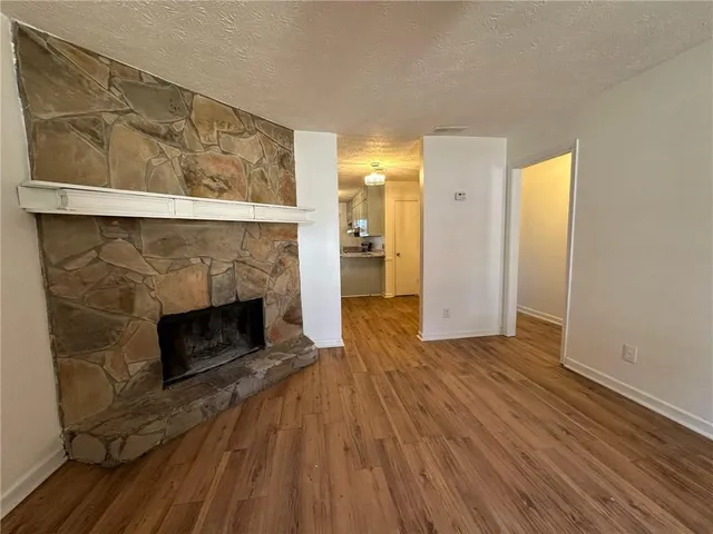 a view of a livingroom with wooden floor and a fireplace