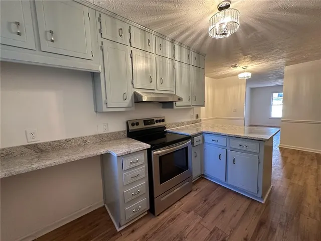 a kitchen with stainless steel appliances granite countertop a stove a sink and a refrigerator