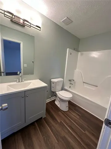 a bathroom with a sink mirror vanity and toilet