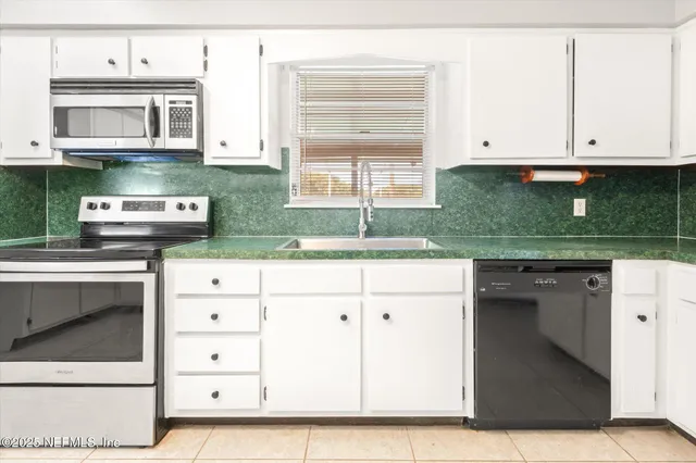 a kitchen with stainless steel appliances granite countertop a stove and a microwave