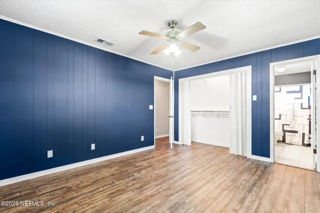 a view of an empty room with a chandelier fan