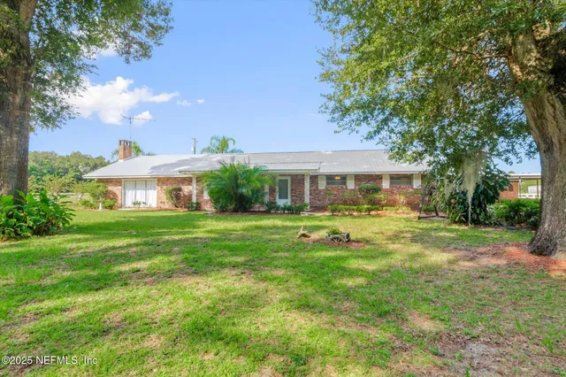 a front view of a house with yard and green space