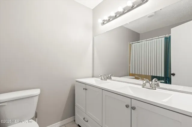 a bathroom with a sink a toilet and a mirror