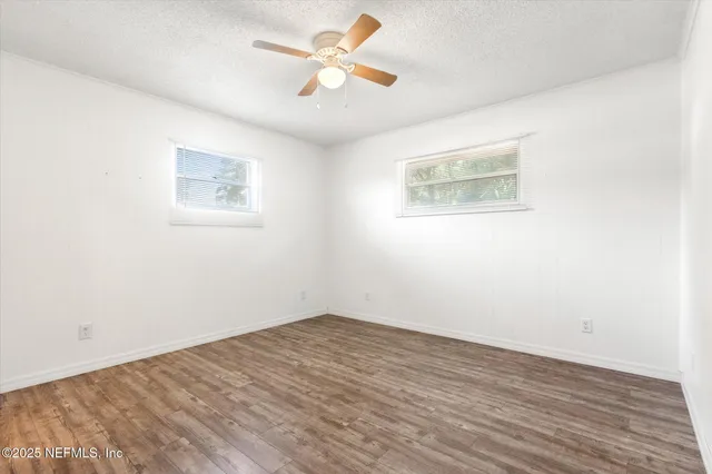 a view of a big room with wooden floor and a ceiling fan