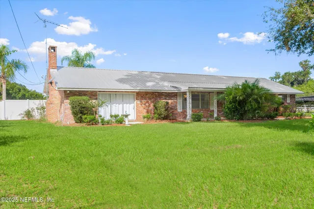 a view of a house with backyard and garden