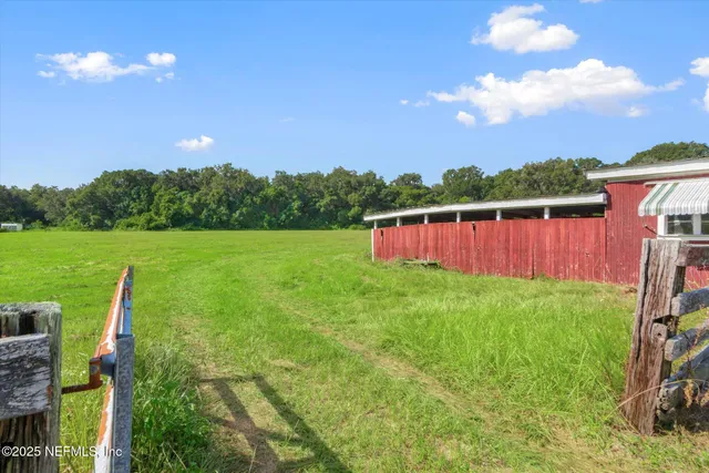 a view of a swimming pool with a yard and sitting area