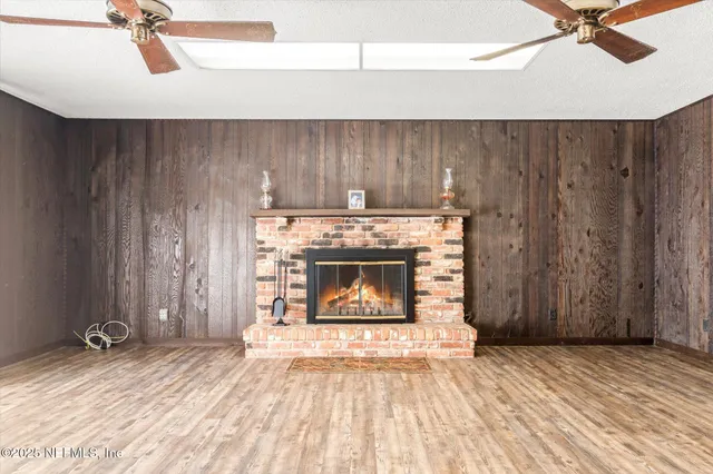 a view of a livingroom with a fireplace and a chandelier fan