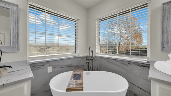 a white bath tub sitting in a bathroom next to a window