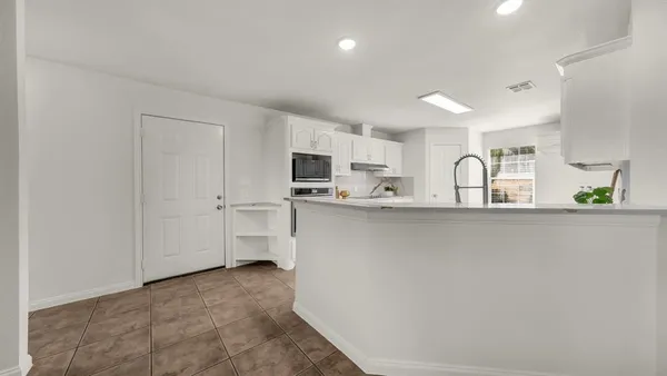 a kitchen with stainless steel appliances a refrigerator sink microwave and cabinets