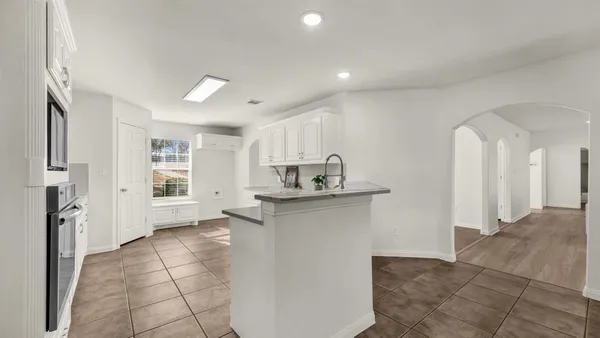 a view of a kitchen with refrigerator and window