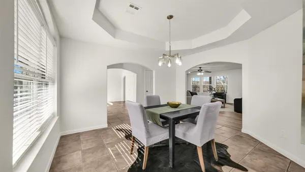 a view of a dining room with furniture and chandelier