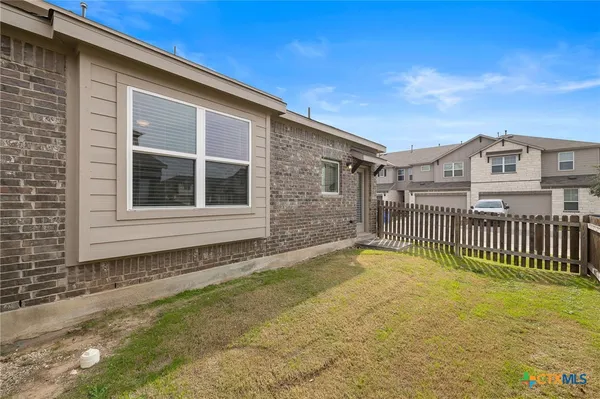 a view of a house with a wooden deck and a yard