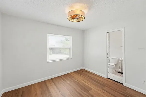 an empty room with wooden floor and window